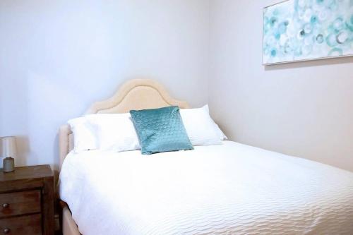 Una cama blanca con una almohada azul encima. en Pristine Harbour View Towers Exec Suite Coffee Parking, en Saint John