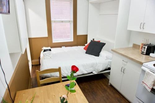 a small room with a bed and a table at Amazing DT Apartment w Parking Location Coffee in Moose Jaw
