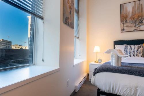 Una cama o camas en una habitación de New Listing Luxurious Downtown Loft Heated Parking Rooftop Patio BBQ Gym Coffee