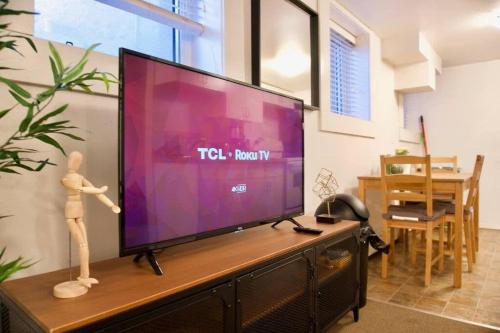 a flat screen tv sitting on top of a entertainment center at Cozy Studio Downtown Parking Coffee Location in Moose Jaw