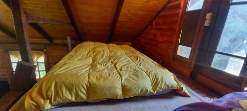 Bett in einem Zimmer in einer Holzhütte in der Unterkunft Cabaña de Troncos en Colonia Suiza in Mendoza