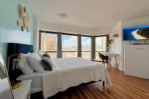 una camera da letto con un grande letto con una grande finestra di 1BR Ocean Sunset View With Parking a Honolulu