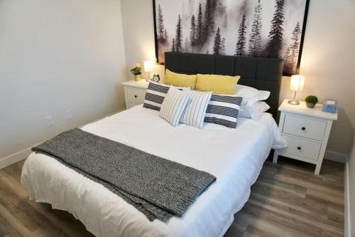 a bedroom with a large white bed with pillows at Gorgeous Modern 2BD Condo Heart of Wpg Coffee Location in Winnipeg