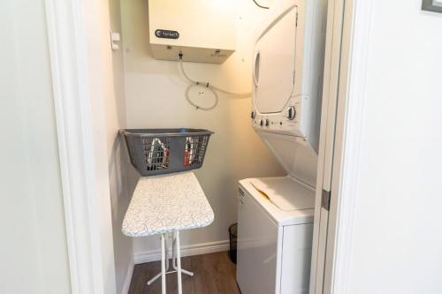 a laundry room with a washer and dryer and a stool at Brand new Gorgeous Condo Near UNB & Hospital Coffee Parking 202 in Saint John