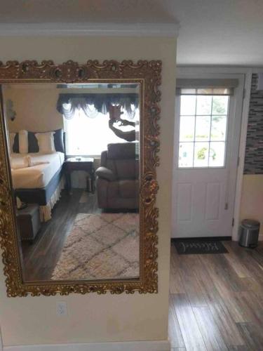 um espelho numa parede numa sala de estar com um sofá em C & N Lodging em Bluffton
