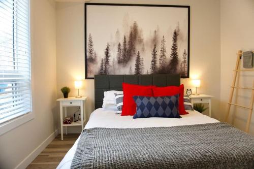 - une chambre avec un grand lit et des oreillers rouges dans l'établissement Premium Modern Condo Top Location 2Bed, à Winnipeg