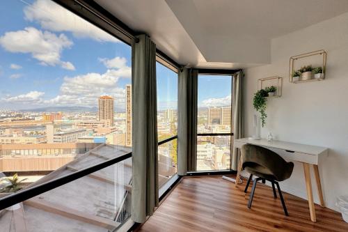 an apartment with a balcony with a desk and large windows at 1BR Ocean Sunset View With Parking in Honolulu