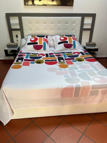 a bed with a white bedspread and pillows on it at Alpinia in Sainte-Anne