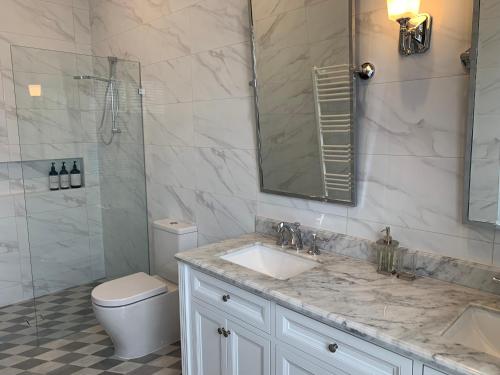 a bathroom with a sink and a toilet and a shower at Rodonia - Cottage in Kew in Melbourne