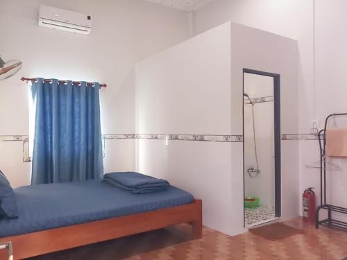 Schlafzimmer mit einem Bett und einem Spiegel in der Unterkunft Đức Phát Homestay in Tân Phú