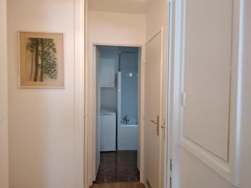 un couloir avec une porte menant à une salle de bains. dans l'établissement Sympa-Appart, à Paris