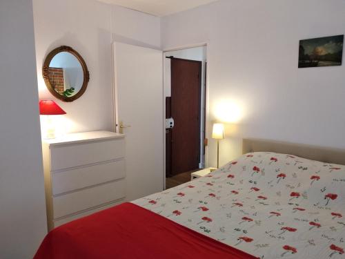 une chambre blanche avec un lit et un miroir dans l'établissement Sympa-Appart, à Paris