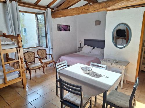une chambre avec un lit, une table et des chaises dans l'établissement Chambres lou castel, à Malves