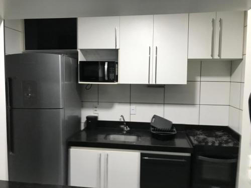 eine Küche mit einer Spüle und einem Kühlschrank in der Unterkunft Quarto no Dubai Residence in São Luís