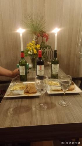 a table with two glasses and bottles of wine at Amonitas Glamping Deluxe in Tinjacá