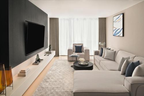a living room with a couch and a tv at Sheraton Grand Hotel, Dubai in Dubai