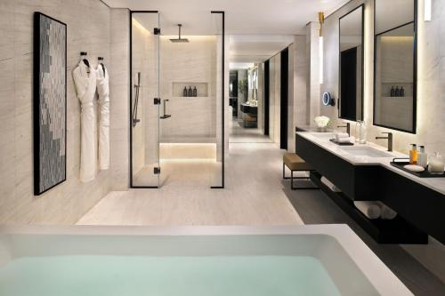 a bathroom with a tub and two sinks and a shower at Sheraton Grand Hotel, Dubai in Dubai