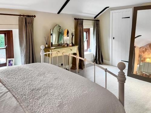 a bedroom with a bed and a dressing table at Mill View Cottage in West Stour