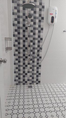 a shower in a bathroom with a checkered shower curtain at baan Thankhun in Ban Rangeng