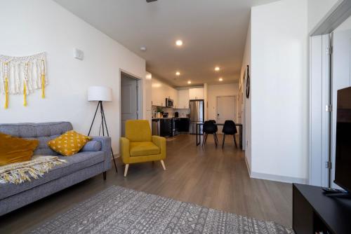 a living room with a couch and a yellow chair at Modern Nulu 2BR CozySuites 01 in Louisville