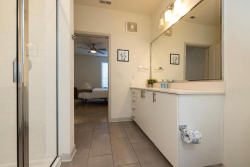 uma casa de banho com um lavatório e um espelho em Modern Nulu 2BR CozySuites 01 em Louisville