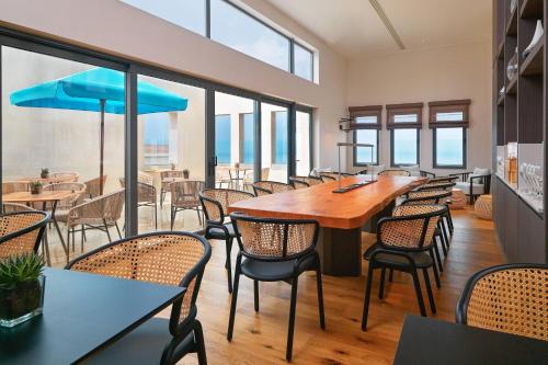 a restaurant with a large wooden table and chairs at Malta Marriott Resort & Spa in St Julian's