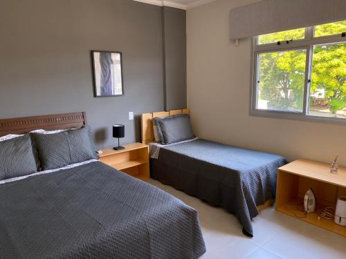 een slaapkamer met 2 bedden en een raam bij Apartamento no centro de São Lourenço 100% reformado in São Lourenço