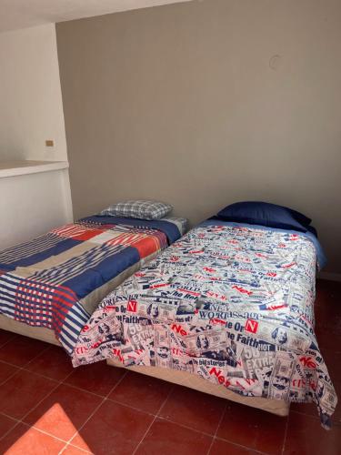 two beds sitting next to each other in a bedroom at Apartamentos Cupules in Mérida