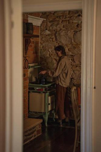 a man standing in a kitchen with a stove at The Old Clarence Brewery in Maclean