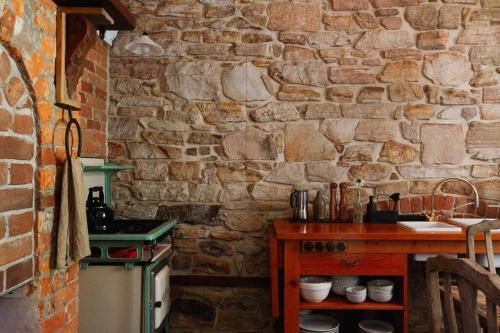 eine Steinküche mit einer Theke und einer Steinmauer in der Unterkunft The Old Clarence Brewery in Maclean