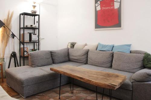 een woonkamer met een grijze bank en een houten salontafel bij Spacious apartment - near Palais Garnier in Parijs