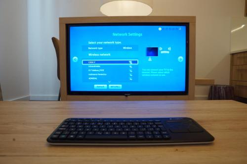 a computer monitor with a keyboard on a wooden table at CASA V BENCUN Luxury Apartments in Zagreb