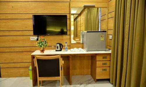 a room with a desk with a computer on it at Dwarka Palace Luxury Hotel in Madurai