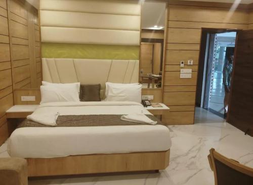 a bedroom with a large bed in a room at Dwarka Palace Luxury Hotel in Madurai