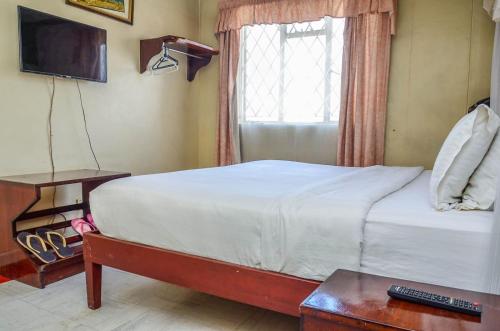 سرير أو أسرّة في غرفة في Blue Hut Hotel