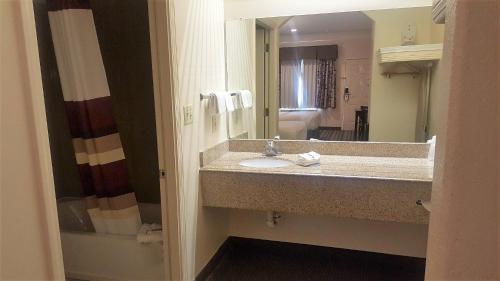 y baño con lavabo y espejo. en Red Roof Inn & Suites Houston – Humble/IAH Airport, en Humble