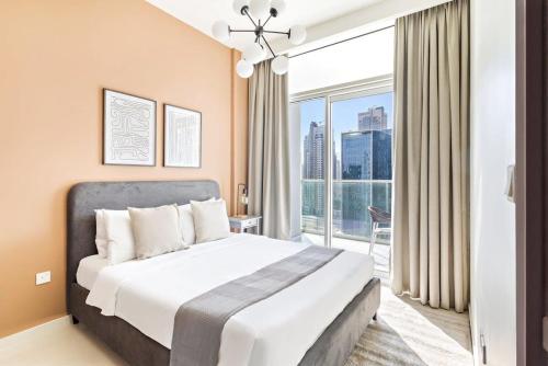 a bedroom with a large bed and a large window at Silkhaus large studio with bedroom in Business Bay's new tower in Dubai
