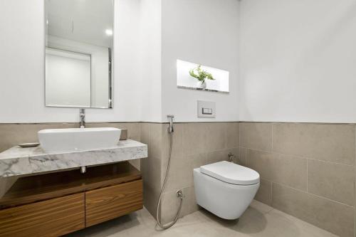 uma casa de banho com um WC, um lavatório e um espelho. em Silkhaus newly furnished 1BDR next to Burj Al Arab em Dubai