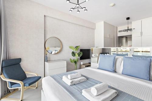 een slaapkamer met een groot bed en een blauwe stoel bij Silkhaus majestic studio with sea view Palm Jumeirah in Dubai