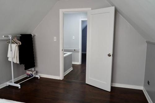 an open white door in a room with wooden floors at 2 Miles UB North, & Ideal Gateway to Niagara Falls in Buffalo