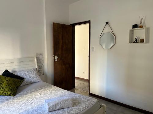 a bedroom with a bed and a mirror and a door at ReMar na Barra, ENSEADA DO PORTO in Salvador