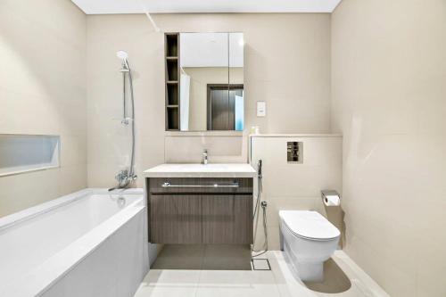 y baño con bañera, aseo y lavamanos. en Silkhaus new 1BDR in Downtown with direct access Dubai Mall, en Dubái