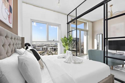 een slaapkamer met een groot wit bed en een groot raam bij Silkhaus quiet neighborhood at Dubai Hills 1BDR in Dubai