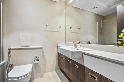 a bathroom with a toilet and a sink and a tub at Silkhaus Al Reem island Modern 1BDR in Abu Dhabi