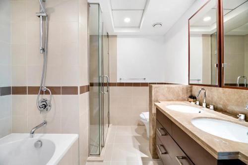 a bathroom with two sinks and a shower at Silkhaus chic 1BDR with patio near Burj Khalifa in Dubai