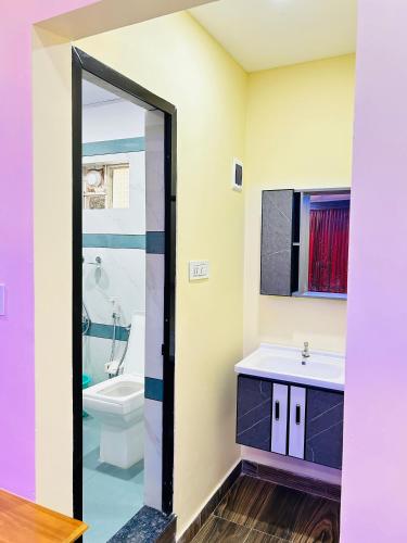 Un baño con lavabo, inodoro y espejo. en Green view suits, en Vythiri