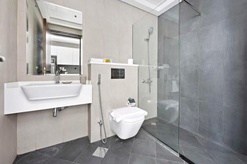 ein Bad mit einem WC, einem Waschbecken und einer Dusche in der Unterkunft Silkhaus beautiful studio in Art Gardens with pool access in Dubai
