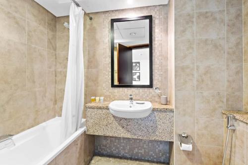 een badkamer met een wastafel en een spiegel bij Silkhaus chic studio in Sky Gardens Pool & Gym in Dubai