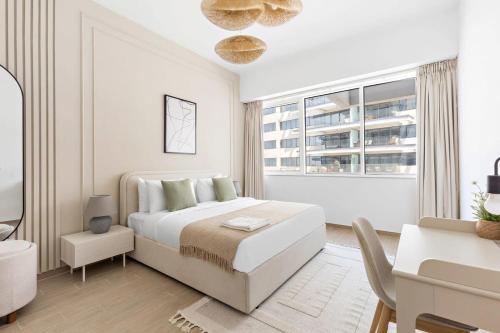 Habitación blanca con cama, escritorio y ventana en Silkhaus Premium Luxury Unit by Aldar with Beach Access en Abu Dabi