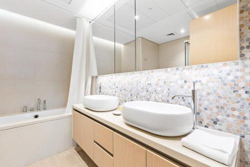 a bathroom with two sinks and a bath tub at Silkhaus Premium Luxury Unit by Aldar with Beach Access in Abu Dhabi